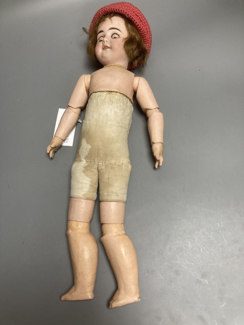 An Armand Marseille bisque boy doll, mould 990 with fixed glass eyes, 30cm, a bisque doll with jointed composition body, 47cm and a pai